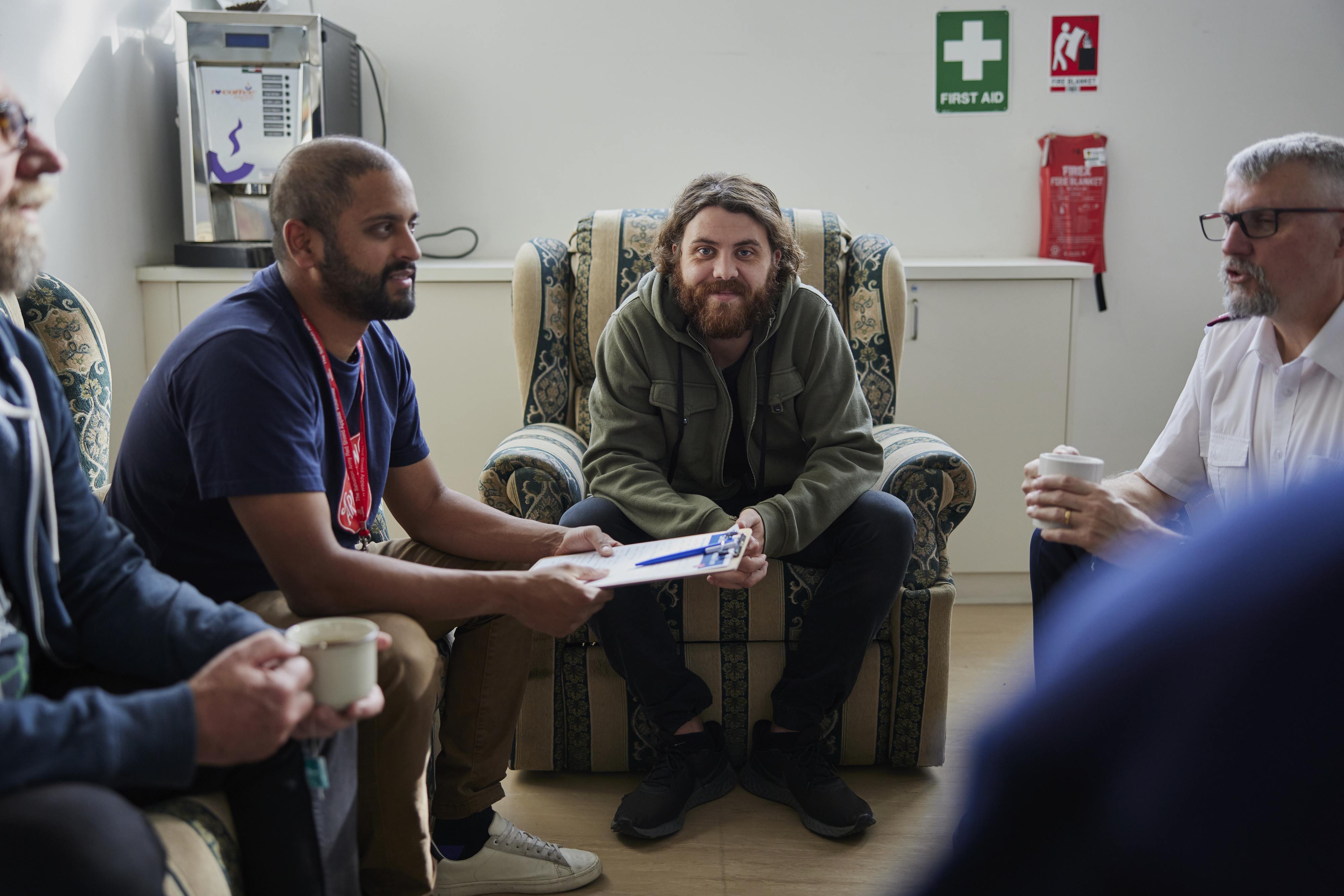 man smiling at camera in group conversation