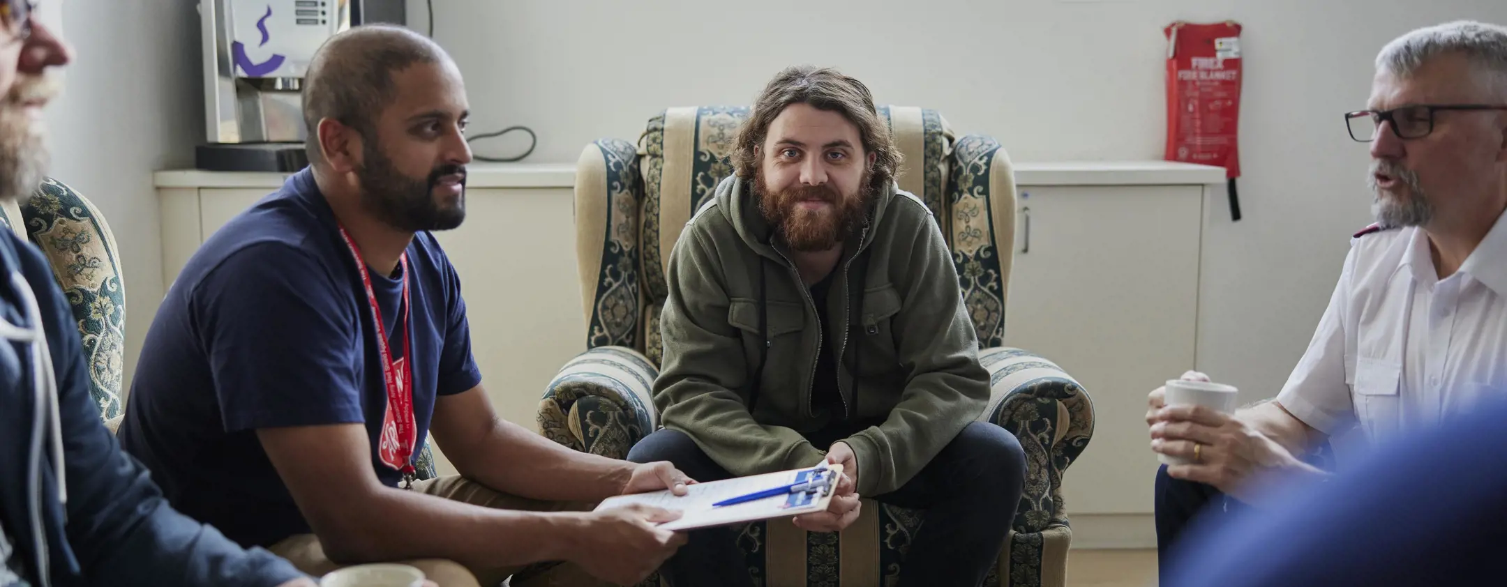 man smiling at camera in group conversation