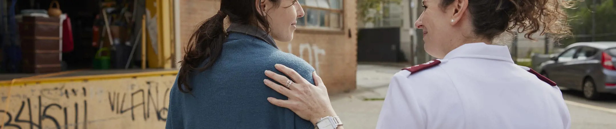 Salvation Army woman with hand on young woman's shoulder