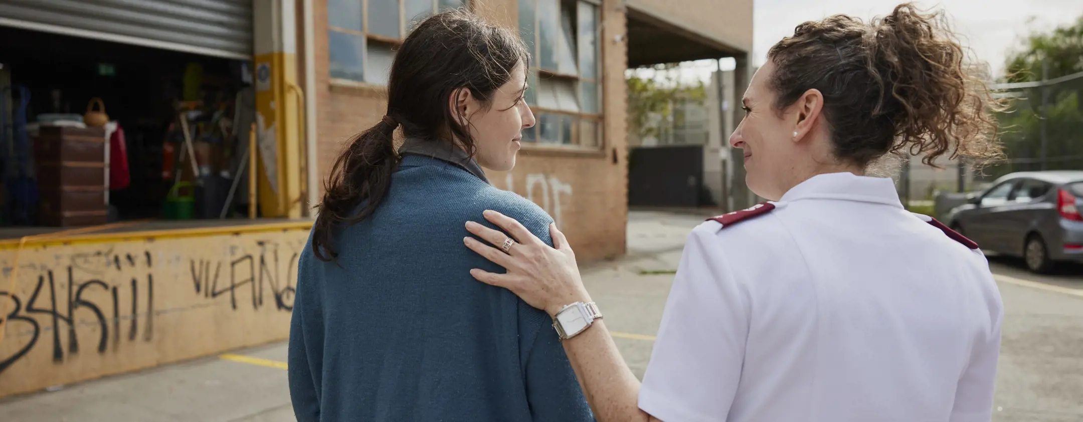 Salvation Army woman with hand on young woman's shoulder