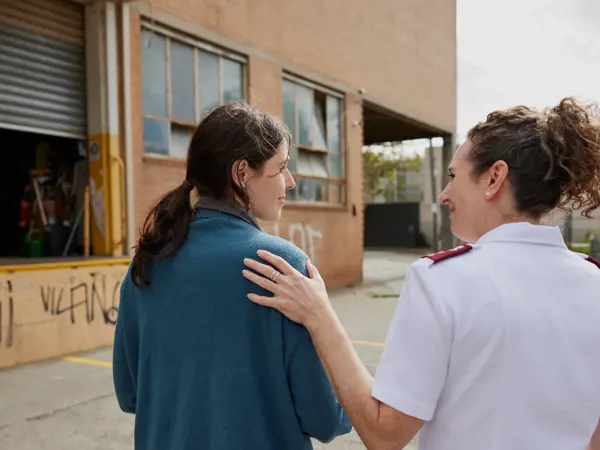 A Salvation Army officer offers a gesture of comfort to a person needing support.