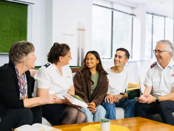 People conversing around coffee table