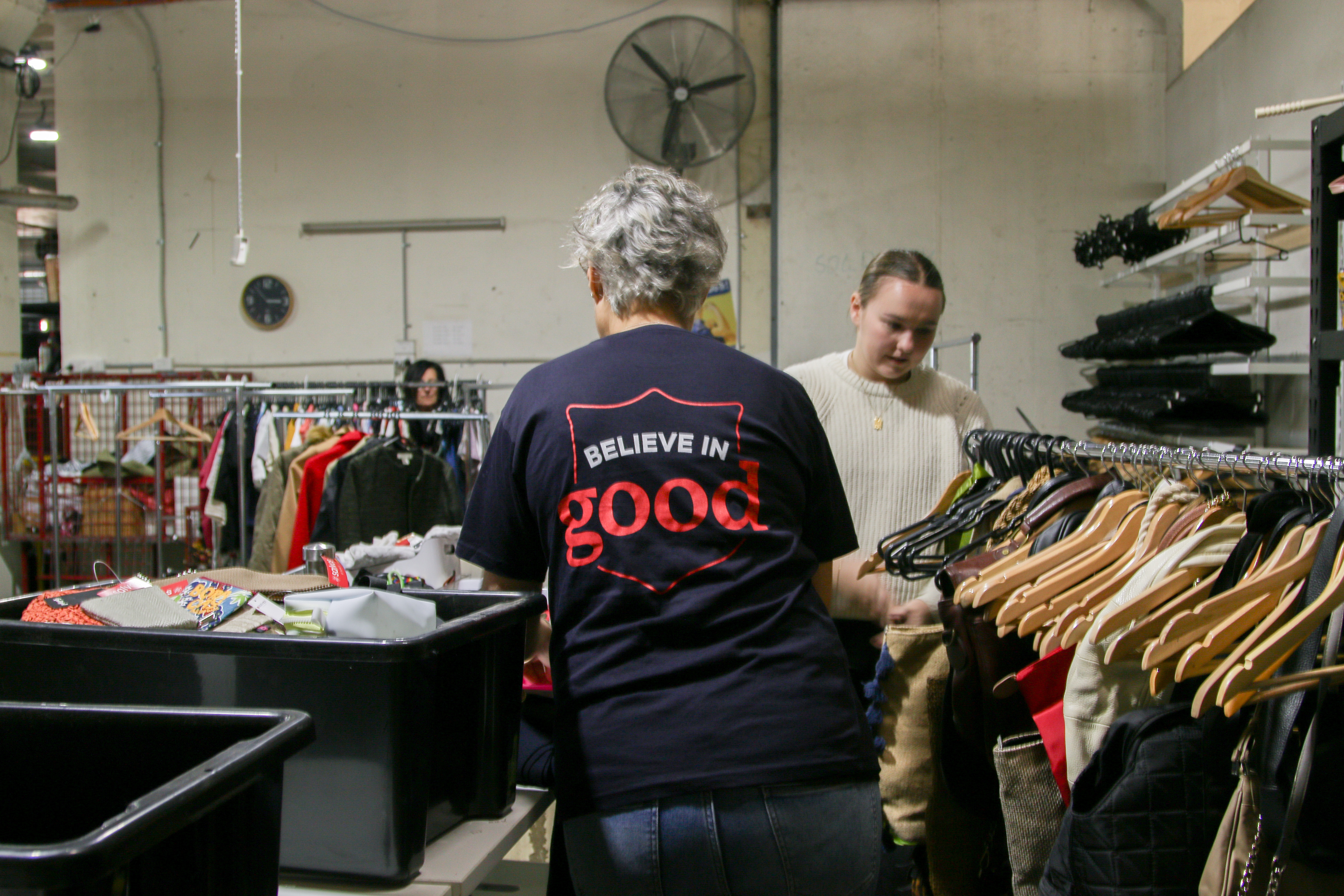 People sorting through clothes at a salvos store