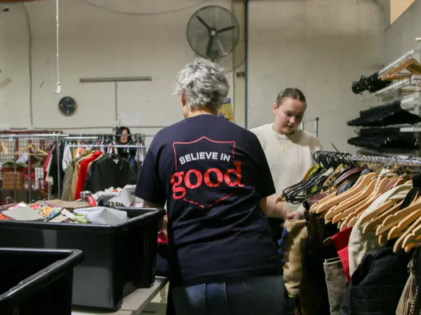 People sorting through clothes at a salvos store