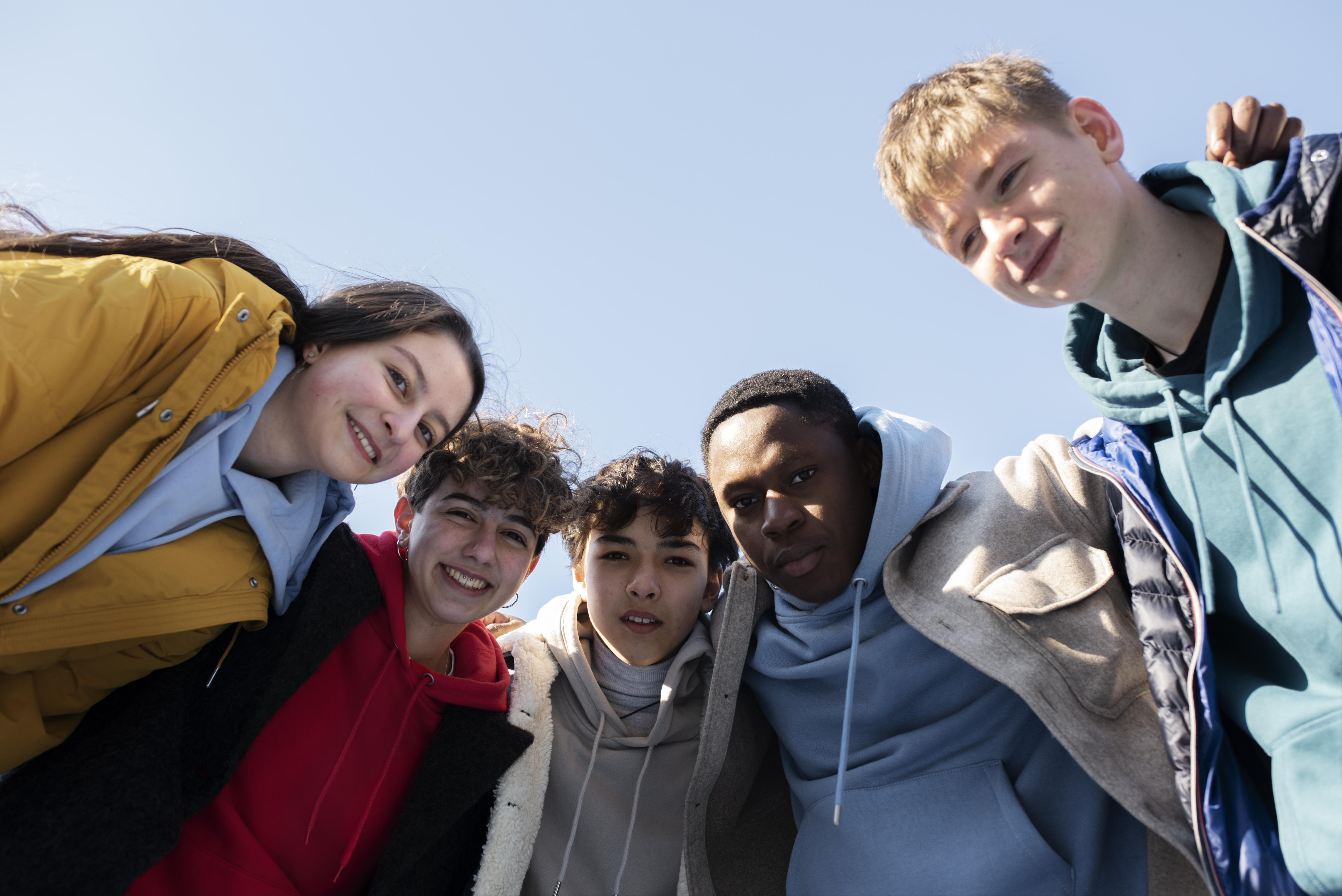 A group of young adults laughing and spending time together outdoors.