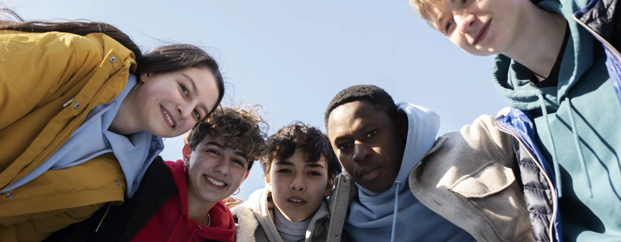 A group of young adults laughing and spending time together outdoors.