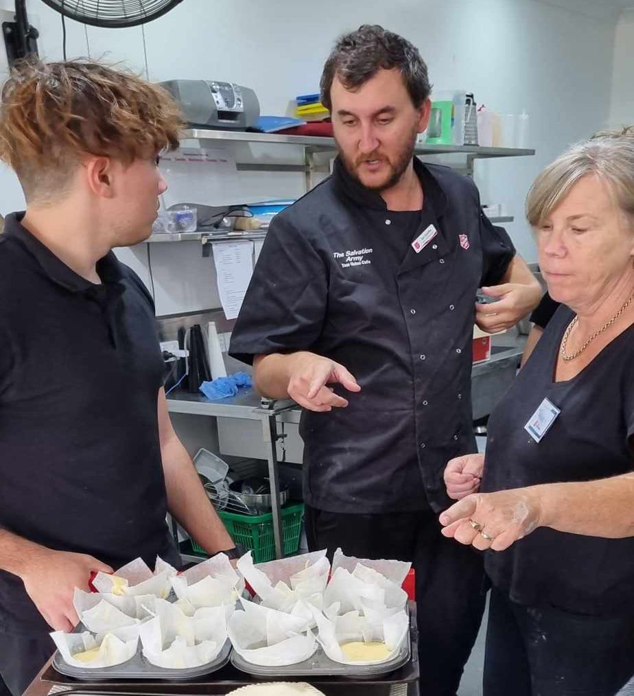 A young man receives expert kitchen hospitality skills from Salvos mentors