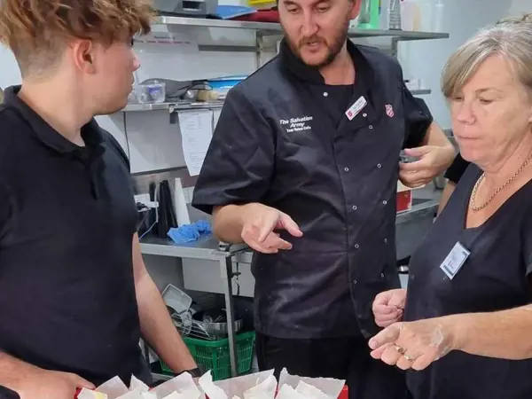 A young man receives expert kitchen hospitality skills from Salvos mentors