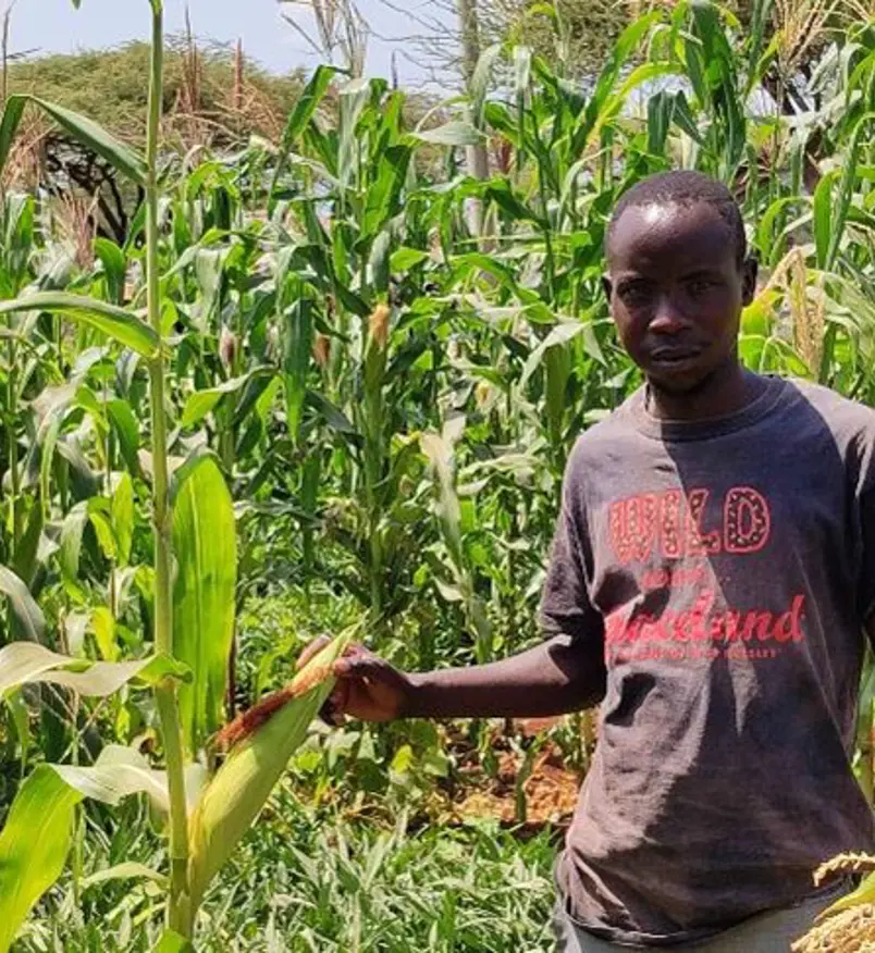 Joseph at his farm where he has been able to produce food for his family. He has planted variety of crops including maize, beans and sweet potatoes.