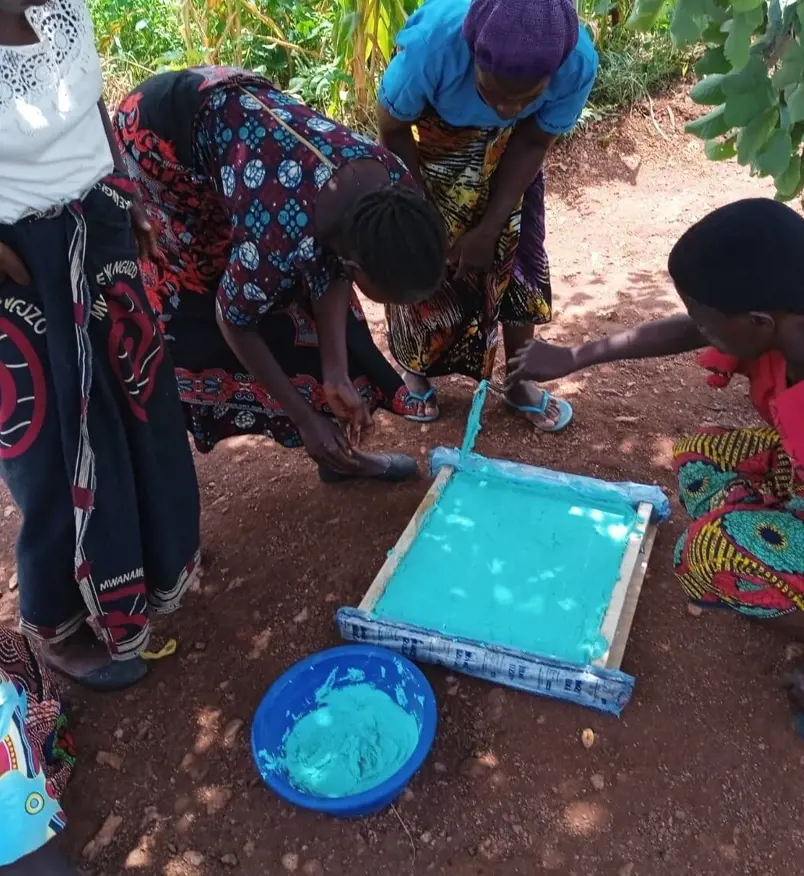 Judith and the group pouring soap into moulds which are later cut and sold.