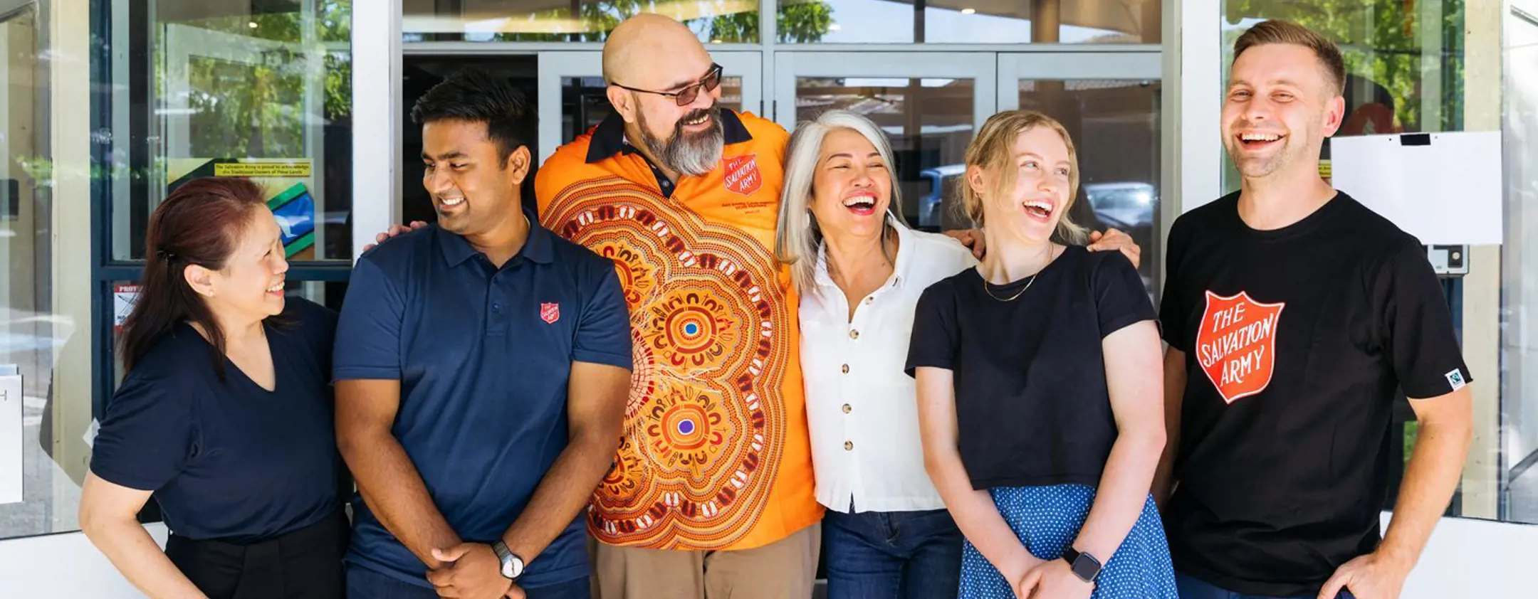 group of Salvation Army people smiling outside building